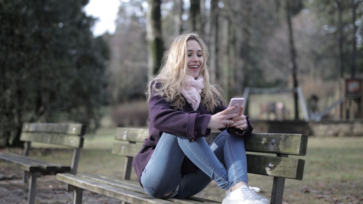 A woman using her phone and smiling